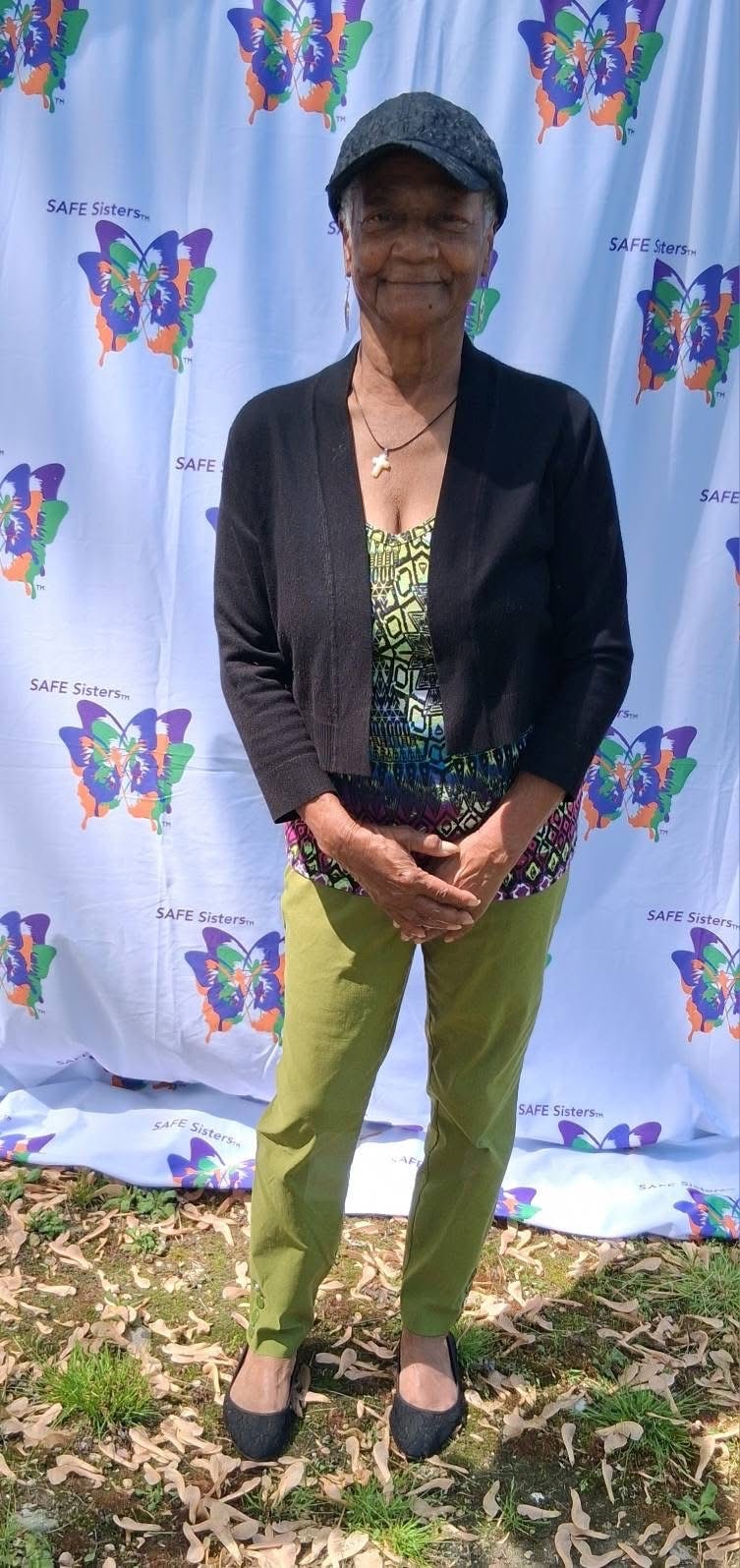S.A.F.E. Sister posing at the branded step-and-repeat backdrop